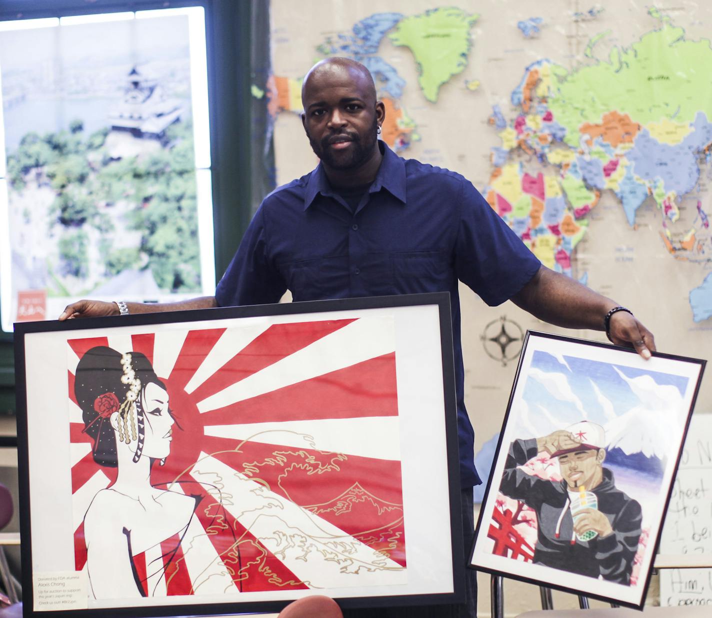 English teacher Bijoun Eric Jordan, who is raising money to plan a trip with students to Japan this summer, shows off art created by current and former students to be auctioned off at Frederick Douglass VII High School in Brooklyn. (Byron Smith/New York Daily News/TNS)