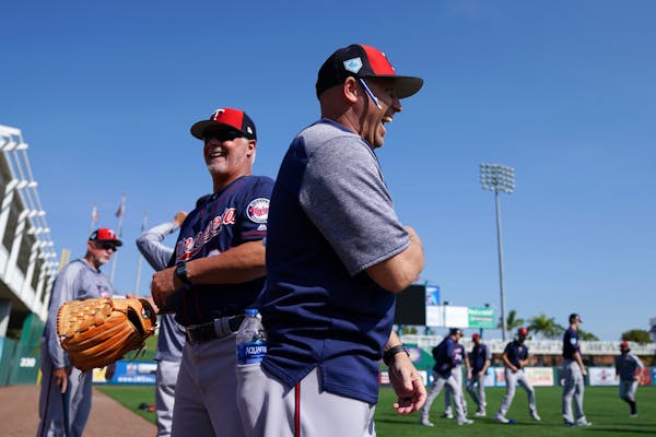 Minnesota Twins pitching coach Wes Johnson (47), right, joked with AAA pitching coach Stu Cliburn as they waited for players to stretch Saturday.