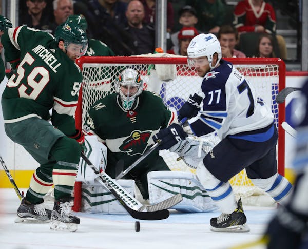 Wild right wing Zack Mitchell (59) moved to clear the puck in front of Minnesota Wild goalie Alex Stalock (32) before Winnipeg Jets center Chase De Le