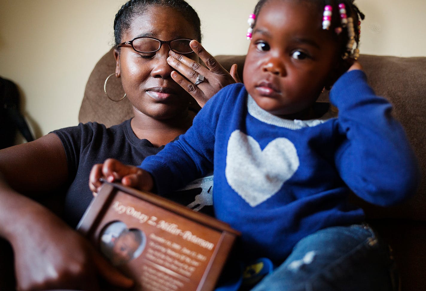 On October 3, 2014 in St. Paul. Ashia Miller holds the urn of her nephew Ke'Ontay while her youngest child, Julianna,2 sits on her. She reported to child protection several times that Key'ontay was being abused by William Warr, a convicted felon. Counties responded by opening family assessment cases. Key'ontay died last year, and Warr is charged with his murder.]Richard Tsong-Taatarii/rtsong- taatarii@startribune.com ORG XMIT: MIN1410051256461119