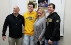 Mitchell Kartes posed with his family, including his father, Kevin (left), his mother, Michelle, and brother, Chris, at the signing ceremony Wednesday
