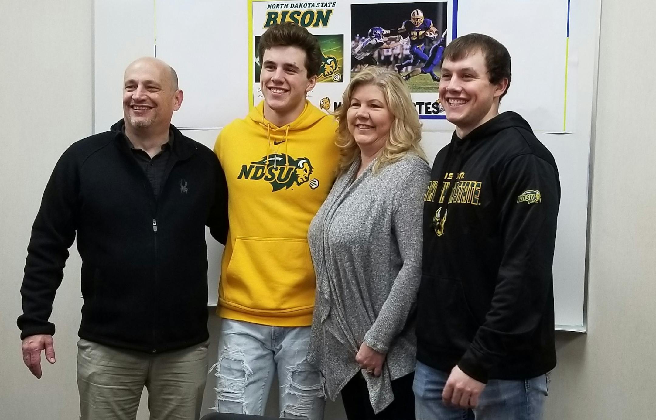 Mitchell Kartes posed with his family, including his father, Kevin (left), his mother, Michelle, and brother, Chris, at the signing ceremony Wednesday at St. Michael-Albertville High School.