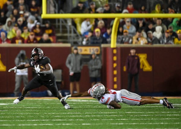Gophers running back Mohamed Ibrahim fell to the turf as he was tackled by Ohio State safety Ronnie Hickman, causing a leg injury.