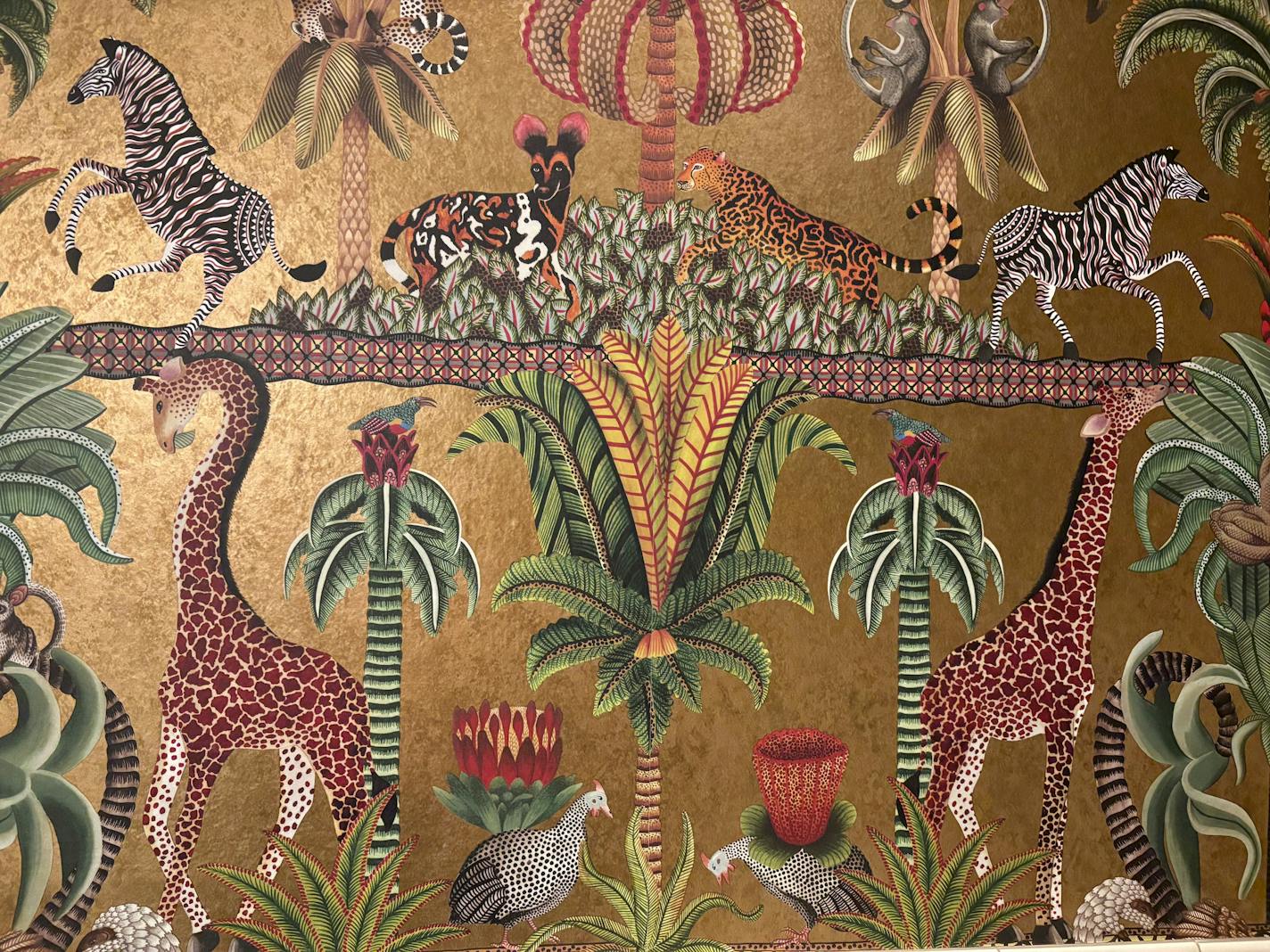 Altera's wallpaper is a gold backgroun with giraffes, zebras and other safari themed animals.