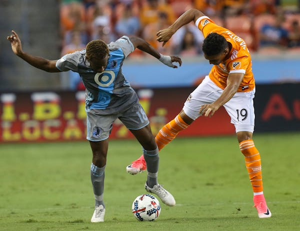 Houston Dynamo forward Mauro Manotas (19) and Minnesota United midfielder Kevin Molino (18) battle for control of the ball during the first half.