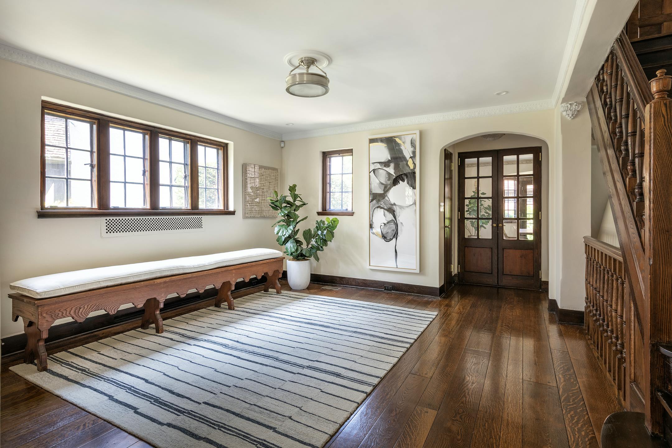 An area rug, greenery and artwork create a warm and cozy entrance to a home. (Provided photo/TNS)