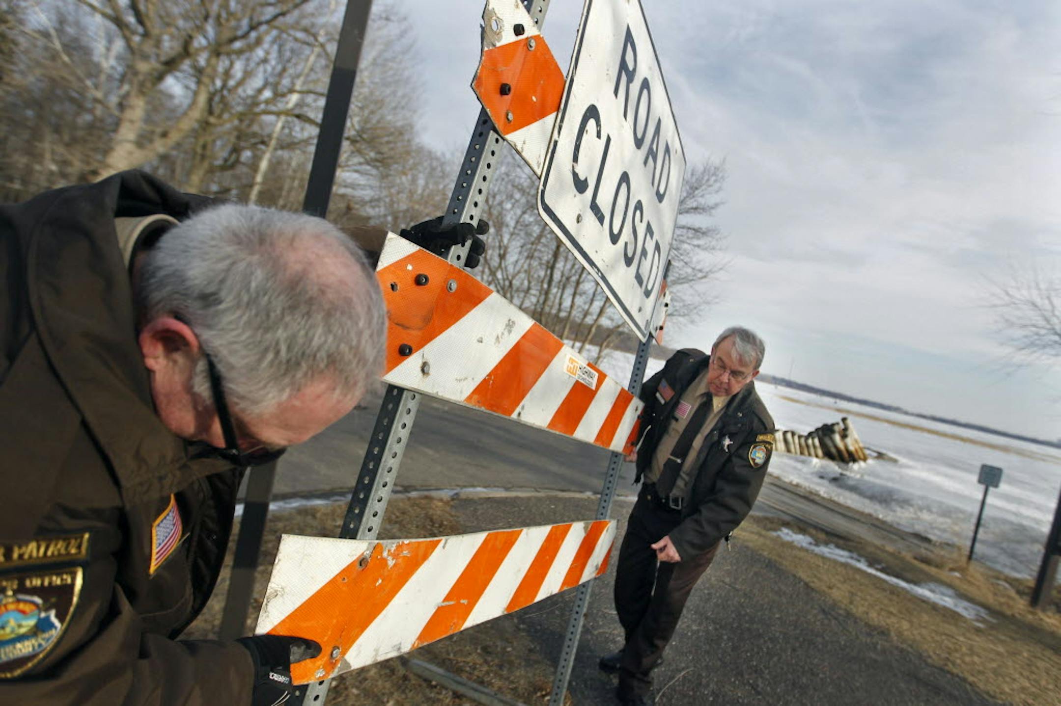 Hennepin County deputies Jim Reuper and Joe Martin moved a "road closed" sign into place at a boat launch on Medicine Lake in Plymouth.