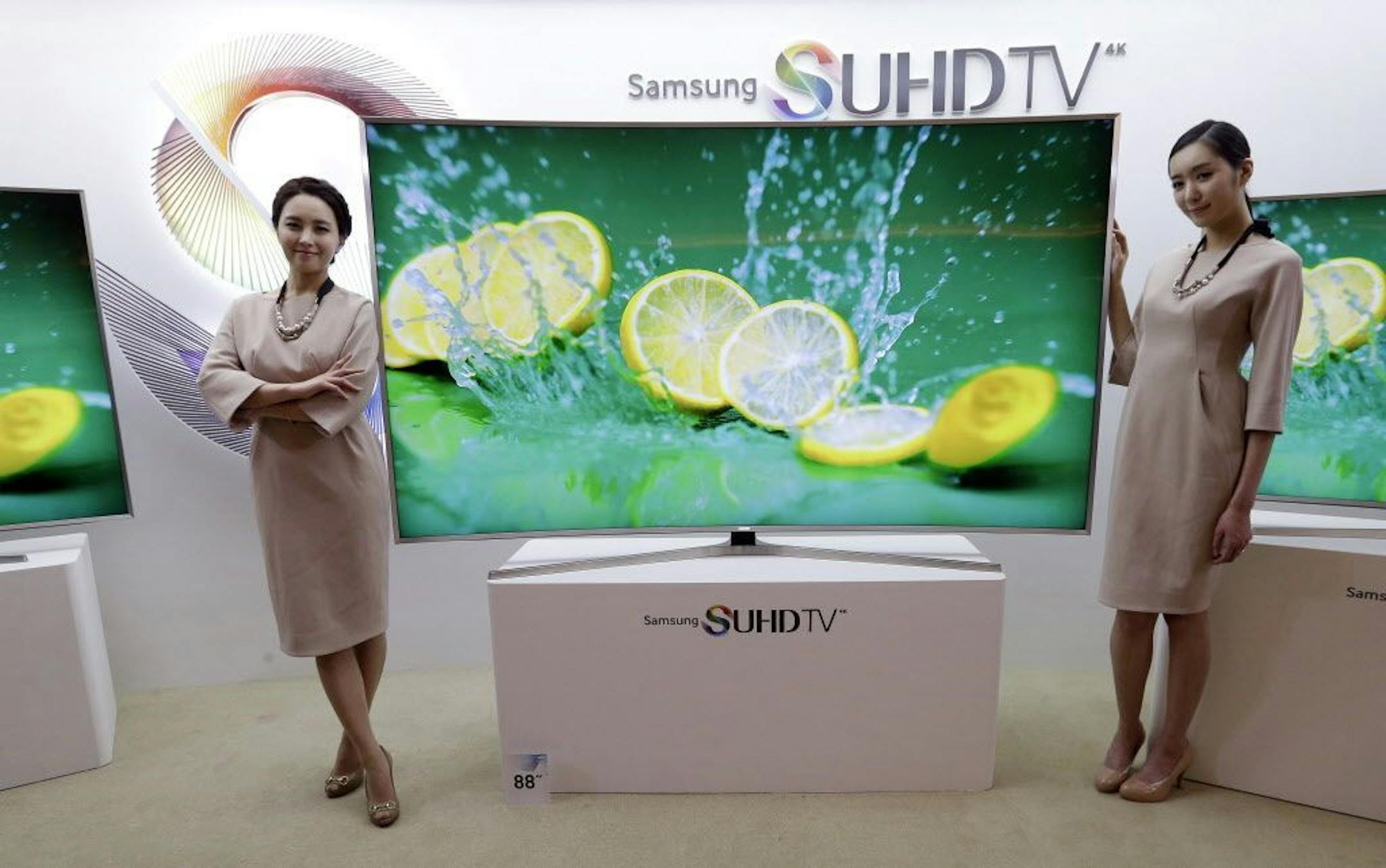 In this Jan. 5, 2015 photo, models pose with a Samsung Electronics Co.' SUHD 4K smart TV during a press conference in Seoul, South Korea.