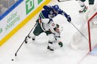 Minnesota Wild's Jonas Brodin (25) battles against Vancouver Canucks' Bo Horvat (53) during the first period of an NHL hockey playoff game Tuesday, Au