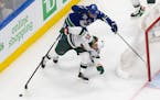 Minnesota Wild's Jonas Brodin (25) battles against Vancouver Canucks' Bo Horvat (53) during the first period of an NHL hockey playoff game Tuesday, Au