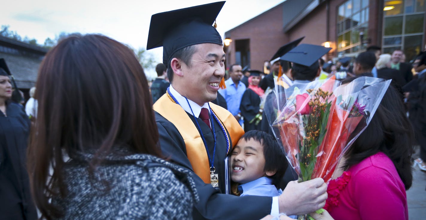 Koua Fong Lee was hugged by his son Yupheng Lee, and other family members after his graduation ceremony at Inver Grove Community College on Thursday, May 15, 2014, in Inver Grove Heights, Minn. Koua Fong Lee graduated from college just a couple years after being released from prison after he was wrongly charged in a crash that was later attributed to Toyota's unintended acceleration problem. ] RENEE JONES SCHNEIDER &#x201a;&#xc4;&#xa2; reneejones@startribune.com