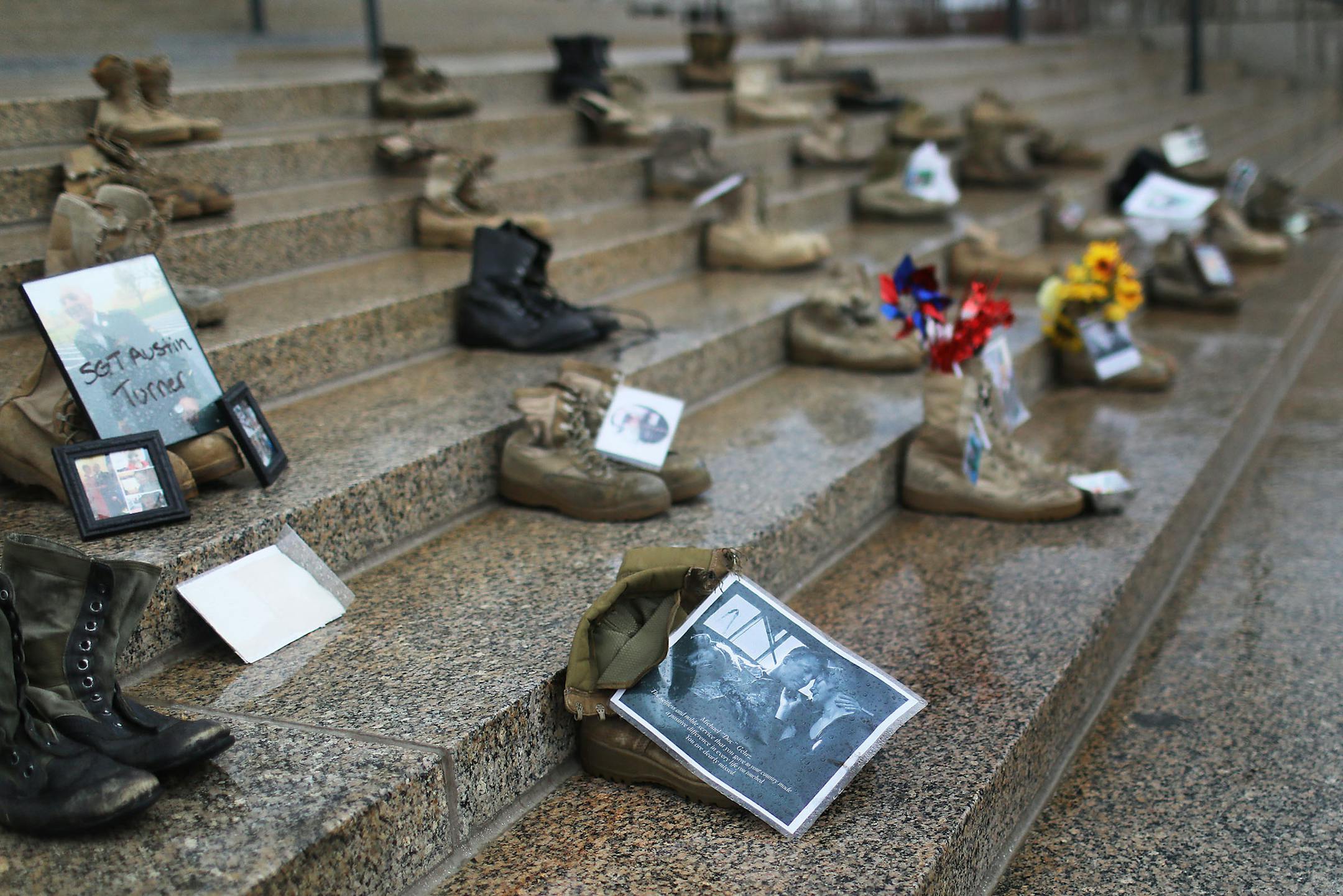 Some of the 60 combat boots placed on the Capitol steps by David Peters, a U.S. Marine from Stillwater who is part of Operation: 23 to 0, including the boots of U.S. Navy medic Michael Gehrz, front, who served two tours of combat service in Iraq and died in 2014. The group placed the boots of soldiers felled by suicide on the steps outside of the State Capitol Wednesday, April 16, in St. Paul, MN. The group's mission is to bring awareness to the suicide crisis among vets and effect change for th