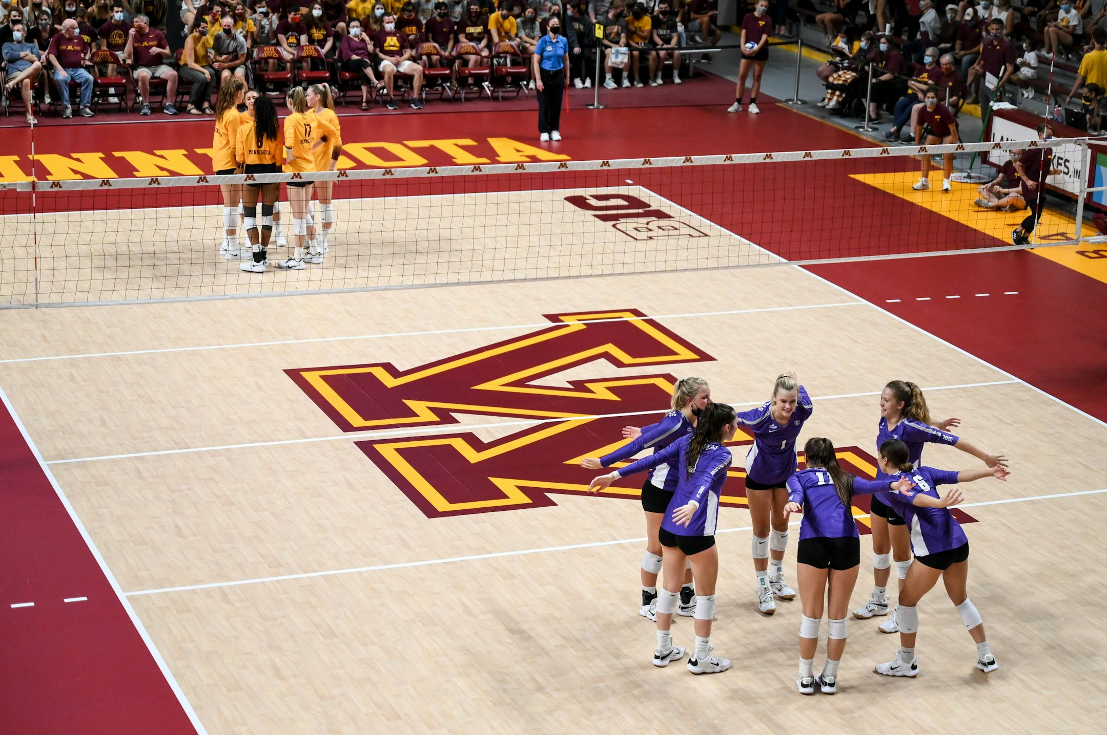 The St. Thomas Tommies huddled up before starting the second set after losing the first to the Gophers.