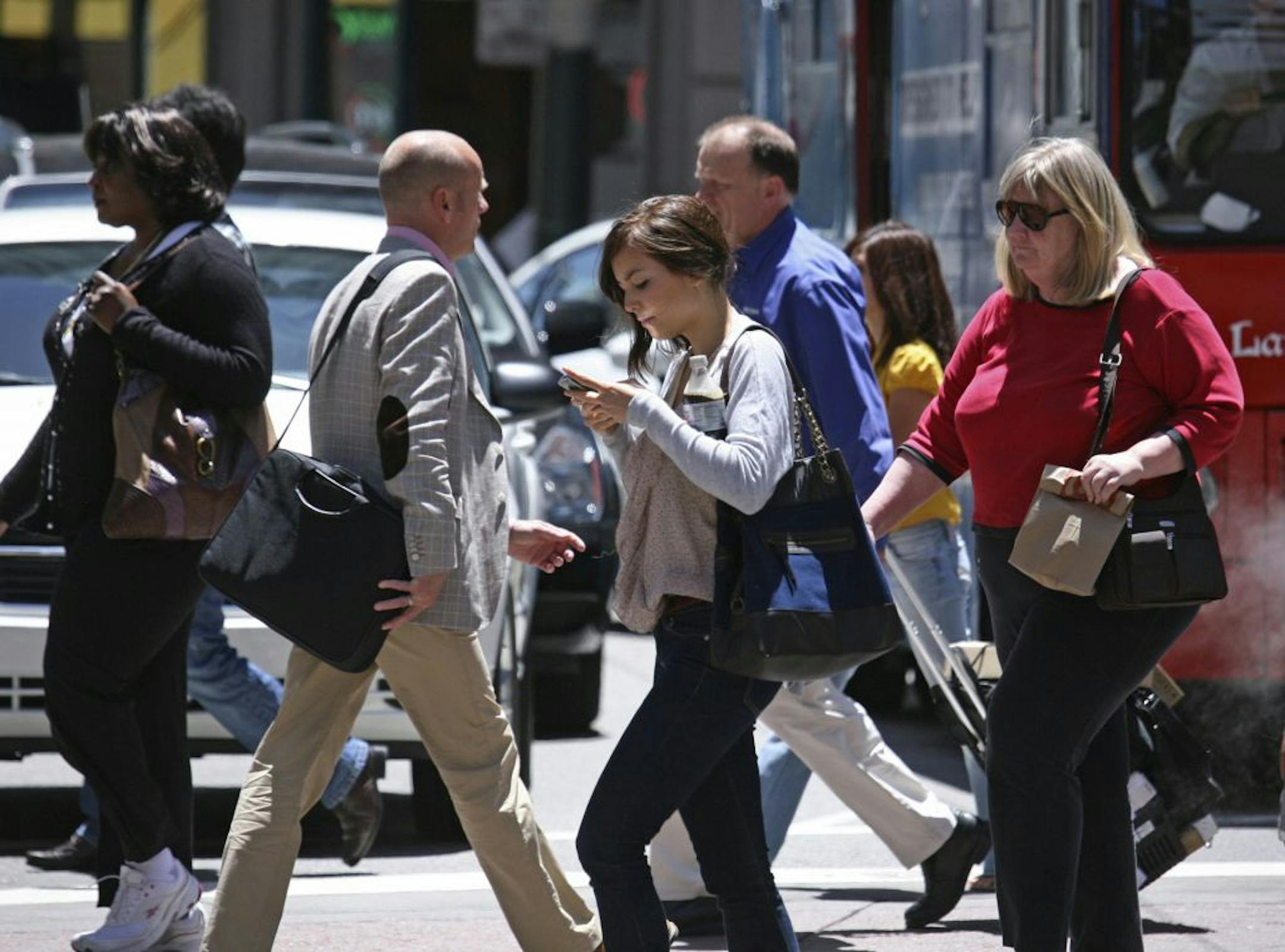 In this photo taken Wednesday, June, 29, 2010, a woman text messages while walking across the street in San Francisco. While using a cell phone while driving has triggered the most alarm bells and prompted laws in several states, experts say pedestrians are also suffering the consequences of mobile distraction tripping on curbs, walking into traffic, even stepping into manholes as they chat or type while walking.