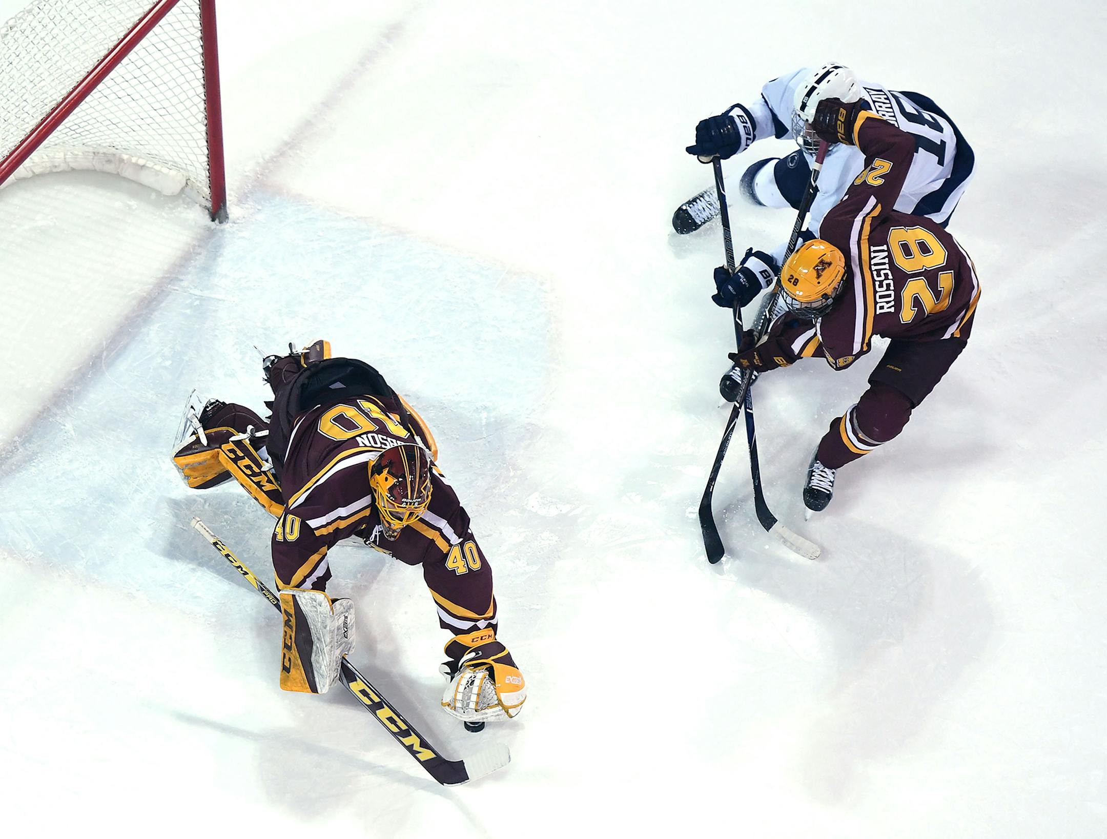 Minnesota goaltender Mat Robson stretches to recover a puck as Minnesota's Sam Rossini (28) fights off Penn State's Brett Murray (18) during Friday's Big Ten quarterfinals.