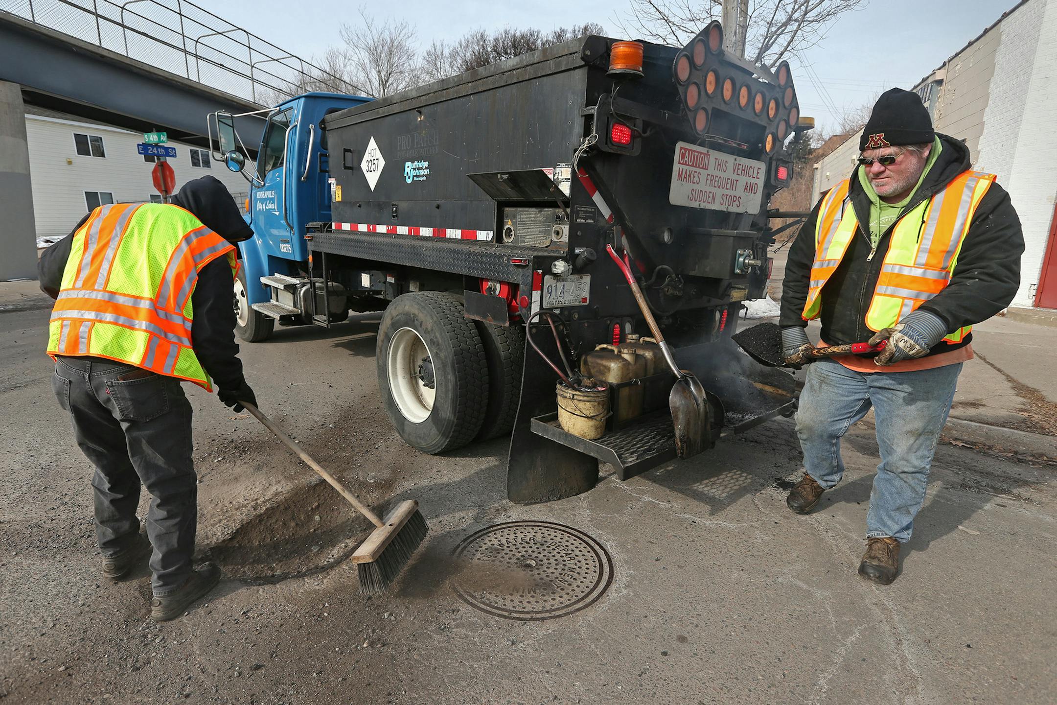 (left to right) Minneapolis city workers Ben White and Mike Flaferty patched potholes near the intersection of 4th Ave South and 24th Street in Minneapolis on 3/26/14.] Bruce Bisping/Star Tribune bbisping@startribune.com Ben White, Mike Flaferty/source. ORG XMIT: MIN1403261552241140