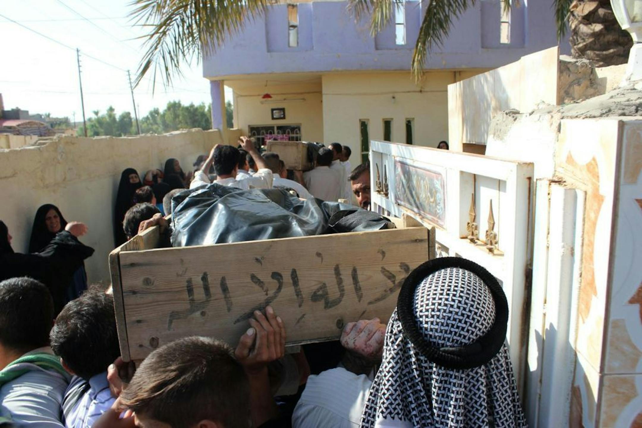Relatives carry the bodies of two slain brothers during their funeral in Baqouba, northeast of Baghdad, Iraq, Friday, July 19, 2013. A bomb hidden in an air conditioner that ripped through a Sunni mosque during midday prayers and other attacks killed dozens in Iraq on Friday, extending a wave of violence targeting worshippers during the holy month of Ramadan.