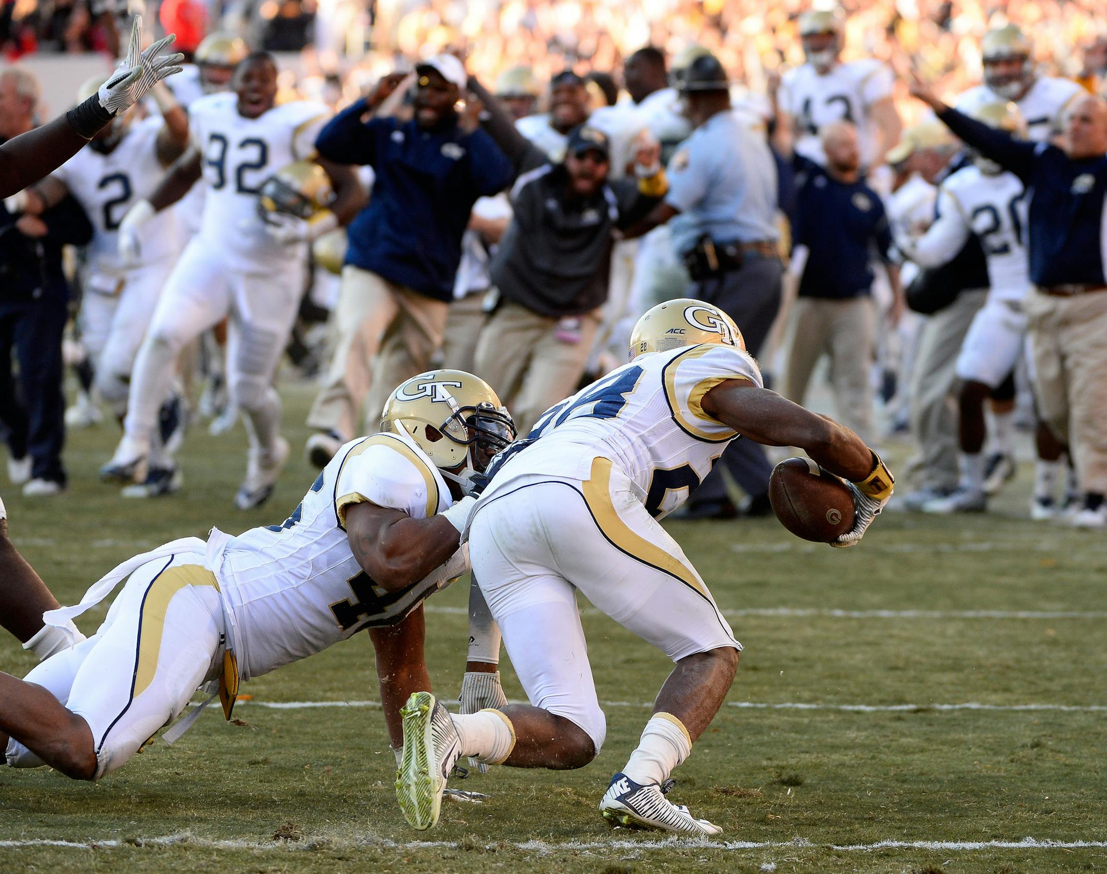 The Georgia Tech bench reacts after defensive back D.J. White (28) intercepted a pass from Georgia quarterback Hutson Mason to seal a 30-24 overtime win in an NCAA college football game Saturday, Nov. 29, 2014, in Athens, Ga. (AP Photo/David Tulis)