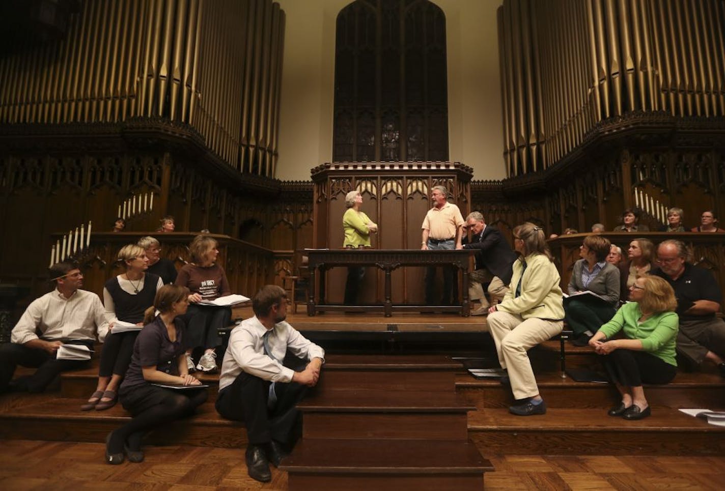 Krista Palmquist and James Bohn, standing at center, and Dan Dressen, seated at center, were surrounded by the chorus during a rehearsal of "The Shoemaker" at Plymouth Congregational Church in Minneapolis.