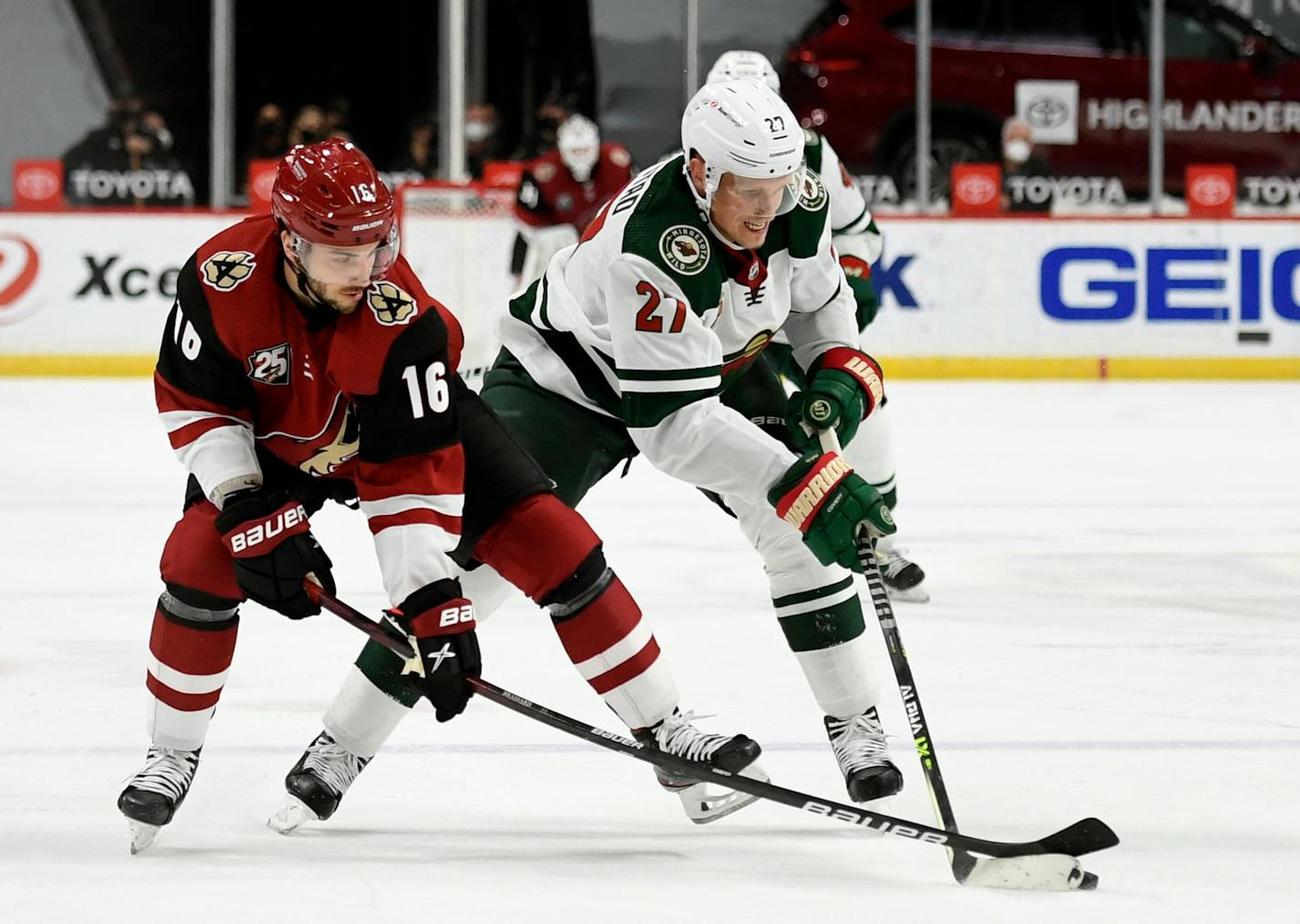 Arizona Coyotes' Derick Brassard (16) and Minnesota Wild's Nick Bjugstad (27) battle for the puck during the second period of an NHL hockey game Tuesday, March 16, 2021, in St. Paul, Minn. (AP Photo/Hannah Foslien)