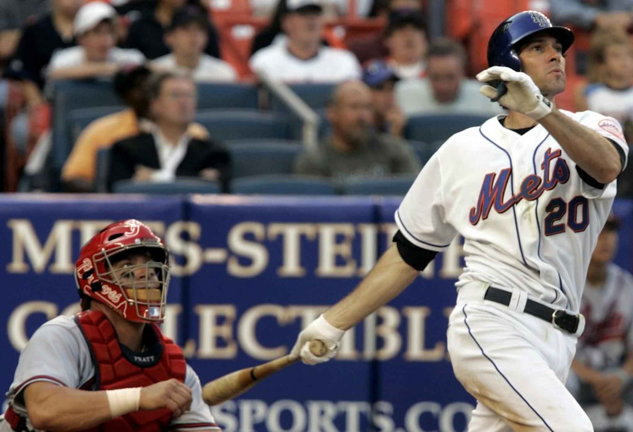 New York Mets' Shawn Green follows through on a two-run home run in the seventh inning of baseball action as the Atlanta Braves' catcher Todd Pratt looks on during the second game of a doubleheader Wednesday Sept. 6, 2006 at New York's Shea Stadium.