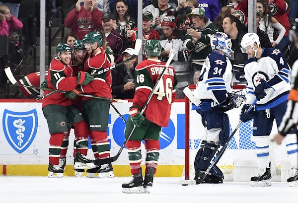 Minnesota Wild left wing Zach Parise (11), forward Charlie Coyle (3) and center Eric Staal (12) celebrate a third period goal by Coyle to put the Wild