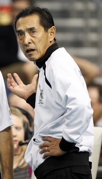 Hawaii coach Dave Shoji, right, discusses a call with official Kevin Cull during the NCAA college volleyball national semifinal match against Penn Sta