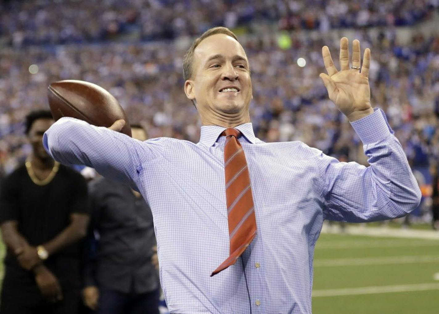 FILE - In this Oct. 8, 2017, file photo, former Indianapolis Colts quarterback Peyton Manning throws a pass during a halftime ceremony at an NFL football game between the Colts and the San Francisco 49ers in Indianapolis.