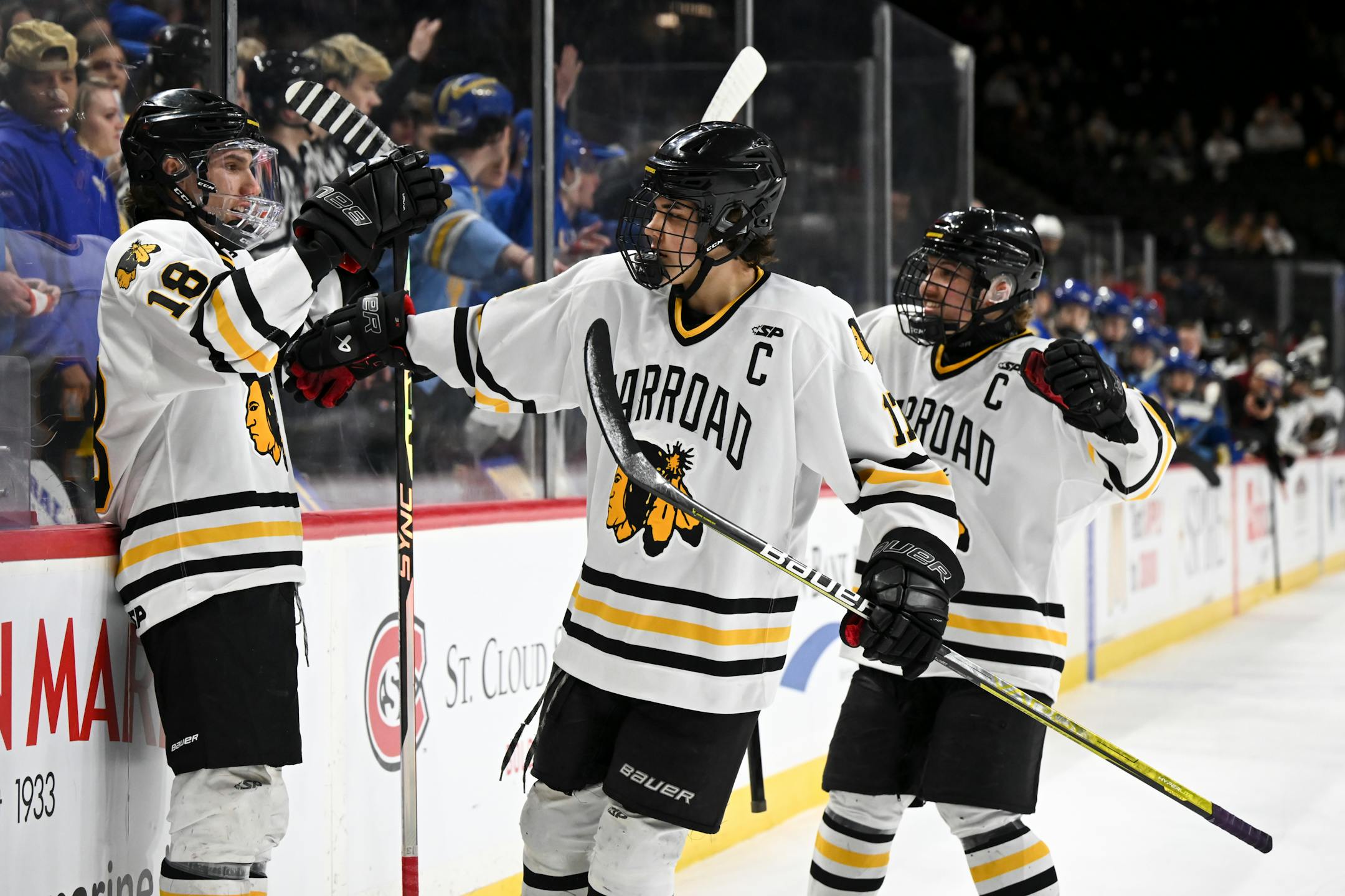 Warroad forward Jayson Shaugabay (17) and defenseman Erick Comstock (2) celebrate with forward Carson Pilgrim (18), left, after his power play goal against St. Cloud Cathedral during the first period.