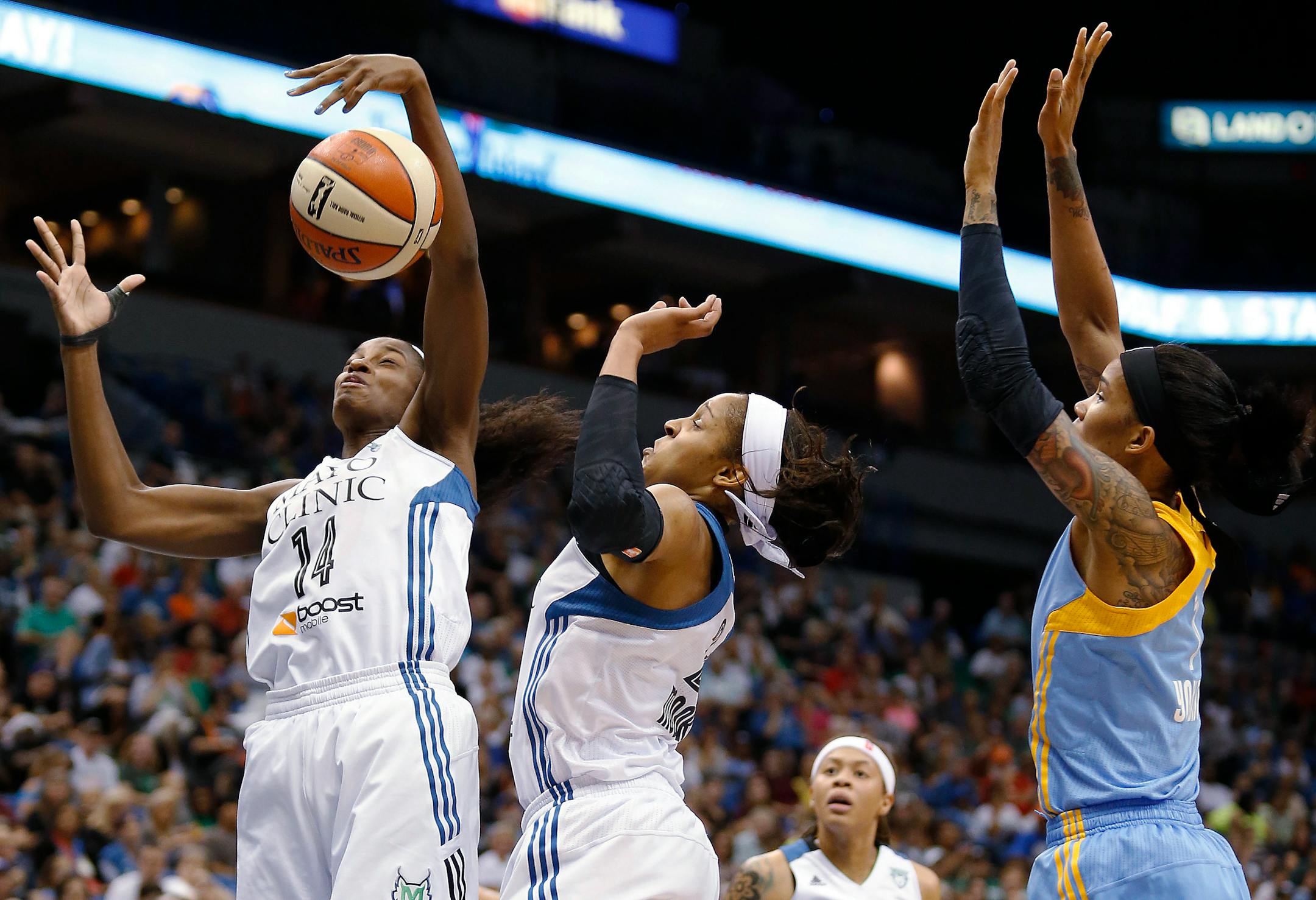 Minnesota Lynx forward Devereaux Peters (14) goes up for a rebound with forward Maya Moore, center, and Chicago Sky forward Tamera Young, right, in the first half of a WNBA basketball game, Thursday, Aug. 7, 2014, in Minneapolis. (AP Photo/Stacy Bengs)