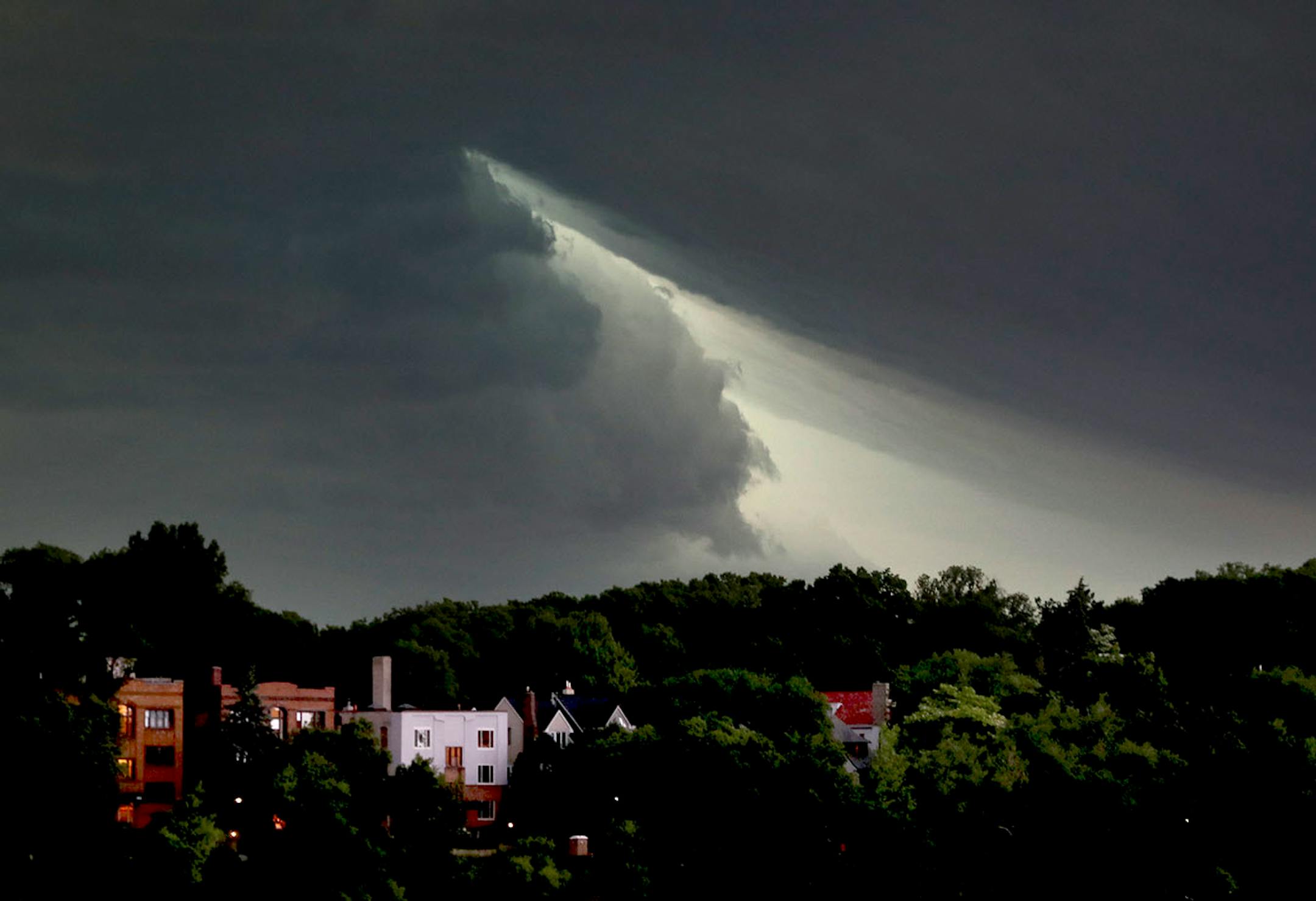 The sky briefly parts as a severe thunderstorm rolls east towards downtown Minneapolis, seen from the south side of Lake Harriet Sunday, June 11, 2017, in Minneapolis, MN.