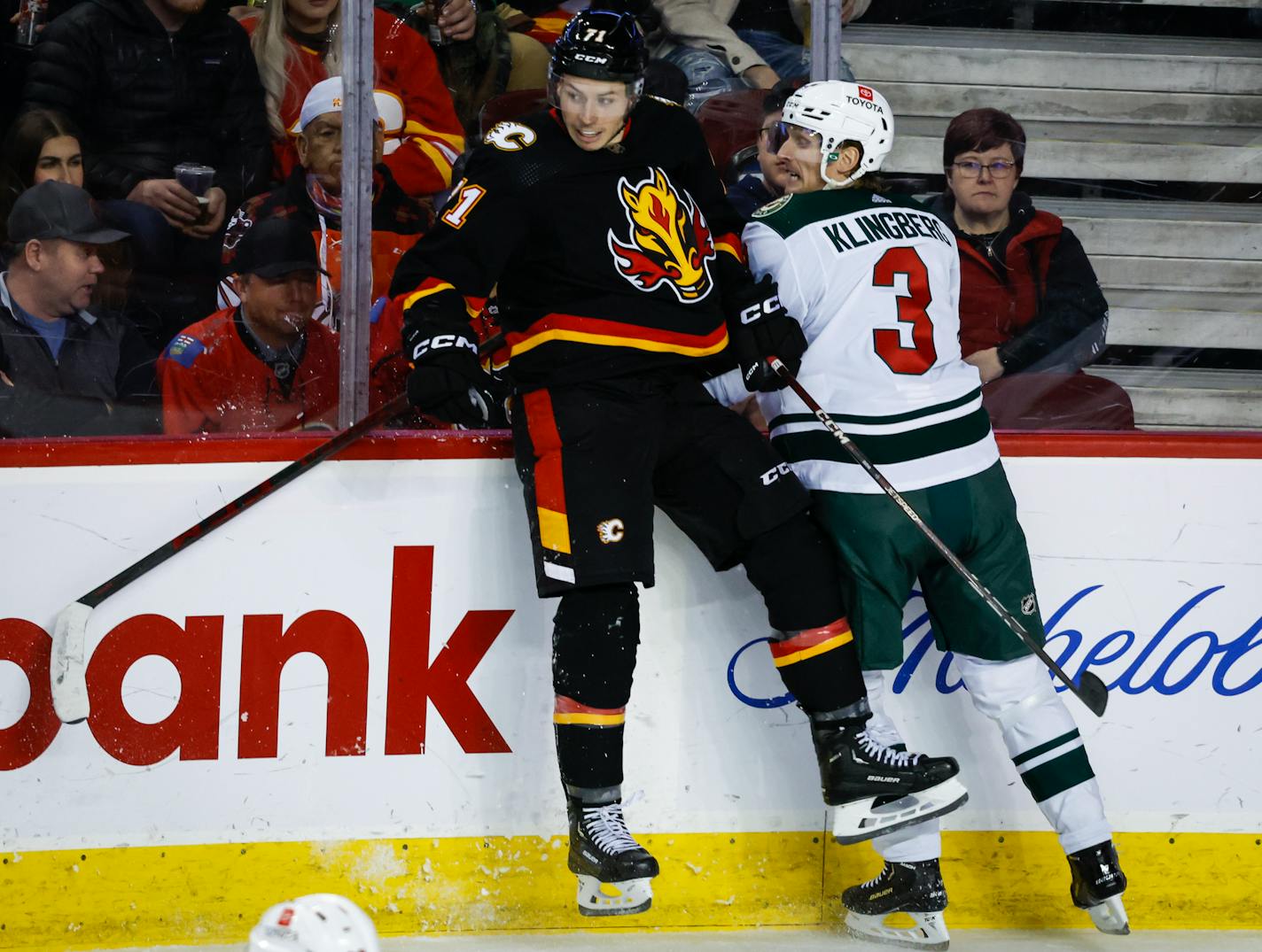 Minnesota Wild defenceman John Klingberg, right, checks Calgary Flames forward Walker Duehr during the second period of an NHL hockey game Saturday, March 4, 2023, in Calgary, Alberta. (Jeff McIntosh/The Canadian Press via AP)