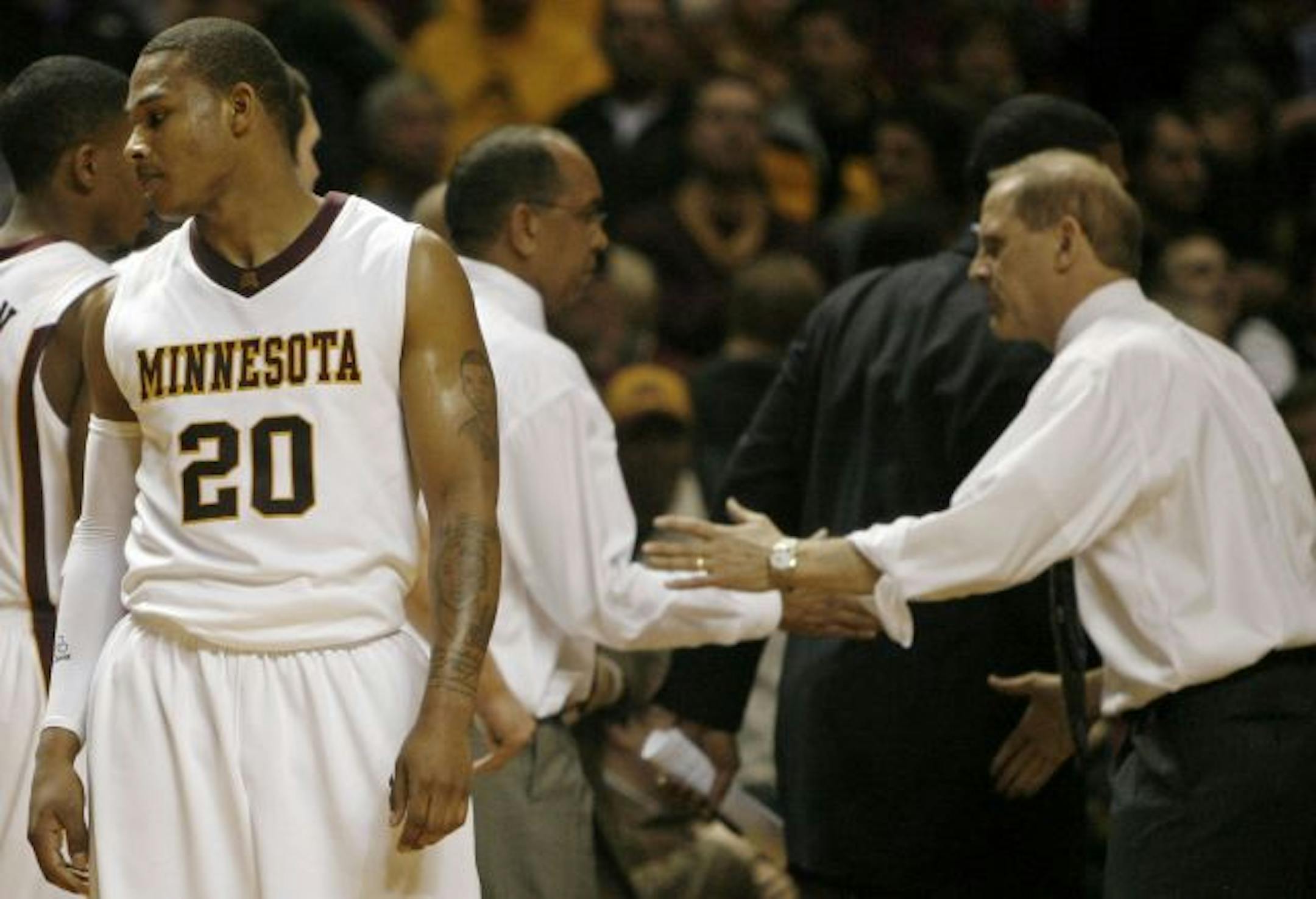 A dejected Lawrence Westbrook at games end as University of Minnesota coach Tubby Smith shakes hands with University of Michigan coach John Beilein after the Gopher's 67-63 loss to Michigan at Wiliams Arena.