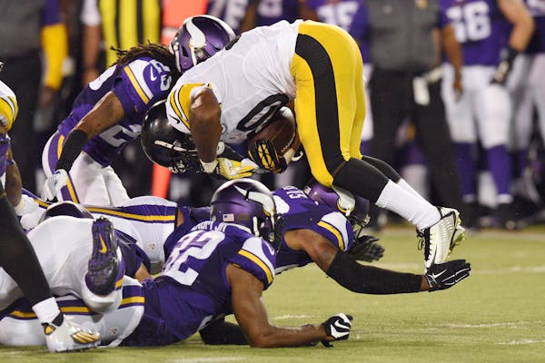Steelers running back Cameron Stingily was upended by Vikings outside linebacker Brandon Watts, center, and cornerback Trae Waynes, left, during the s