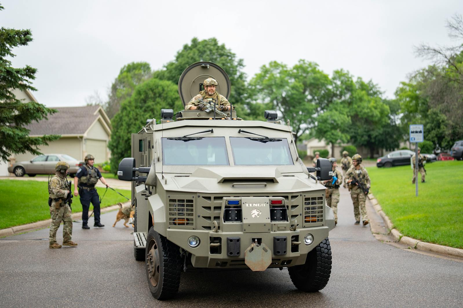 Armed FBI agents with an armored vehicle search for an active shooter by sweeping a neighborhood adjacent to the home of Minnesota DFL State Representative Melissa Hortman in Brooklyn Park on Saturday, June 14, 2025. More than a dozen agents searched parked cars, backyards, sheds and other hiding places while also knocking on doors to speak with residents.  
