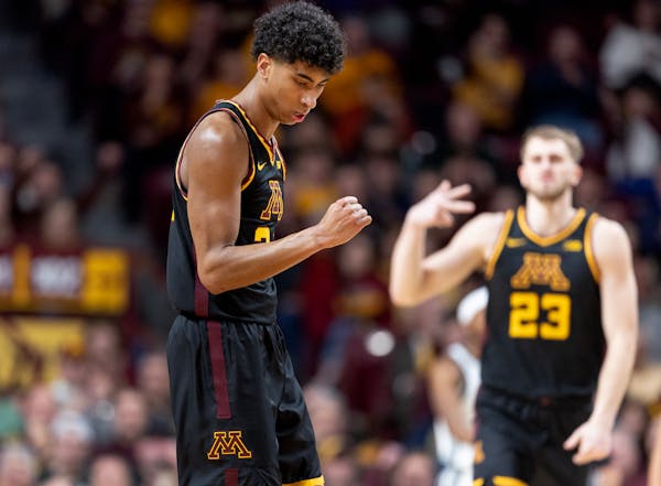 Gophers freshman guard Cam Christie, left, celebrated a three-pointer against Michigan State on Tuesday with teammate Parker Fox (23).