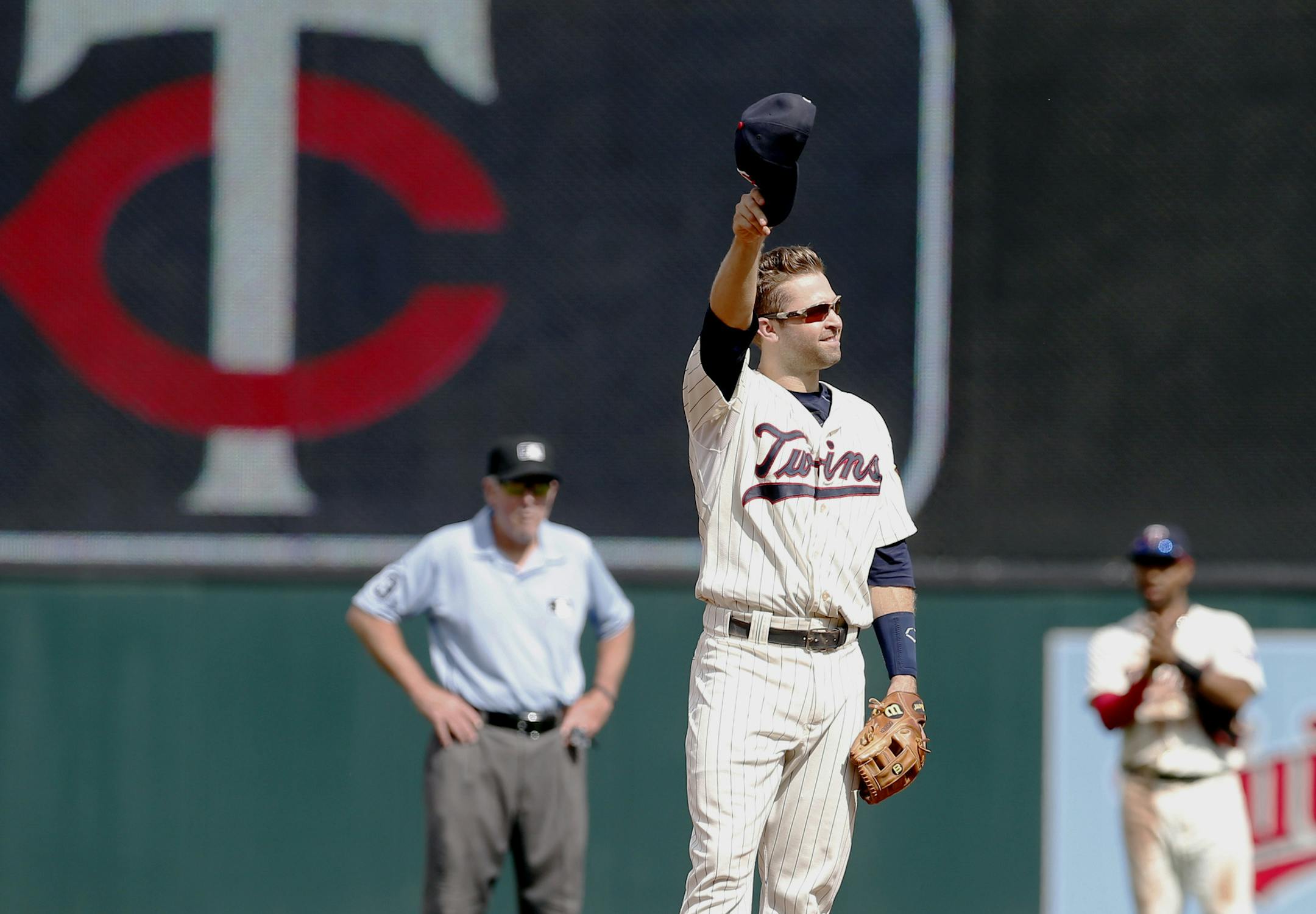 Minnesota Twins second baseman Brian Dozier acknowledges a standing ovation by fans after it was announced during the baseball game against the Detroit Tigers that he was named to the American League All-Star team, replacing injured Blue Jays' Jose Bautista, Saturday, July 11, 2015, in Minneapolis. (AP Photo/Jim Mone)