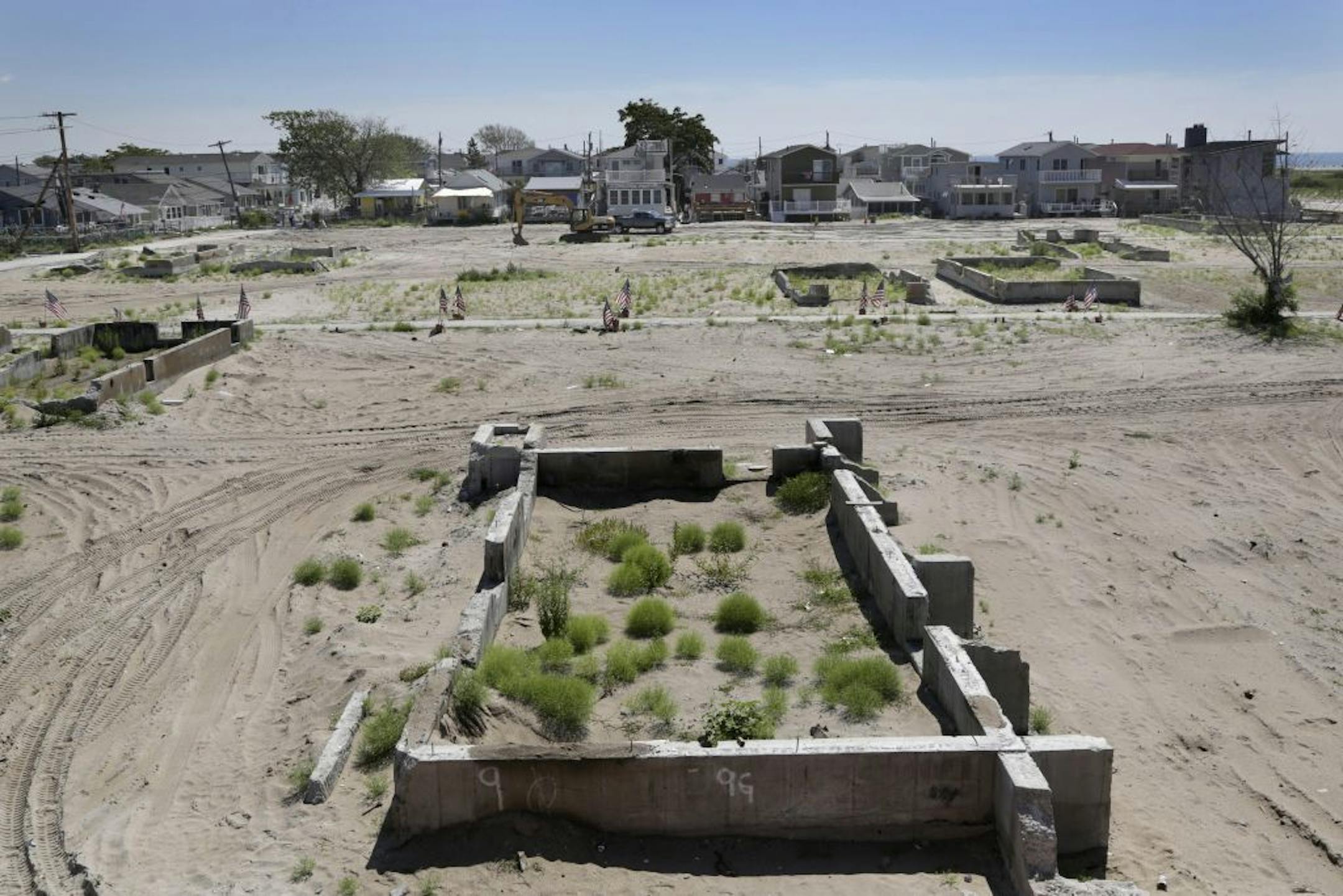 In this Aug. 2, 2013 photo, the battered foundations of homes that burned to the ground during Superstorm Sandy are all that remain in a section of Breezy Point in the Queens borough of New York.