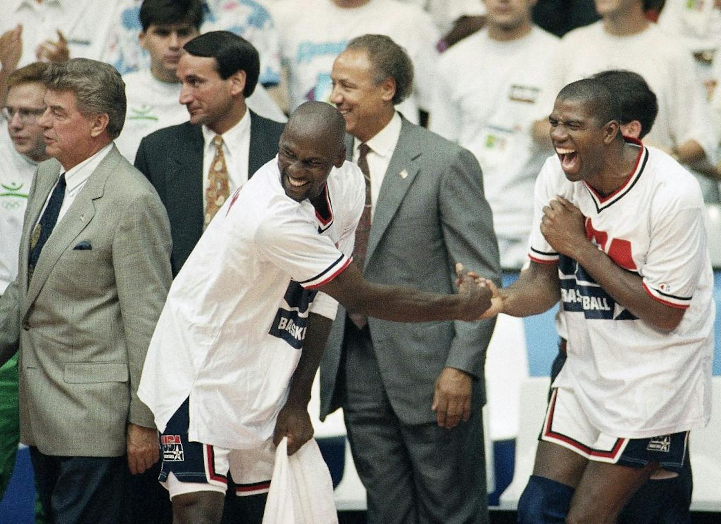 FILE - In this Aug. 8, 1992, file photo, USA's Earvin "Magic" Johnson, right, and Michael Jordan shake hands near the end of their 117-85 win over Croatia in the gold medal game in men's basketball at the Summer Olympics in Barcelona. Head coach Chuck Daly, left, and his assistant coaches Mike Krzyzewski, second left, and Lenny Wilkens, center, look on It's not an urban legend: The Dream Team really did lose a scrimmage to a group of college stars as the future Hall of Famers prepared for the 19