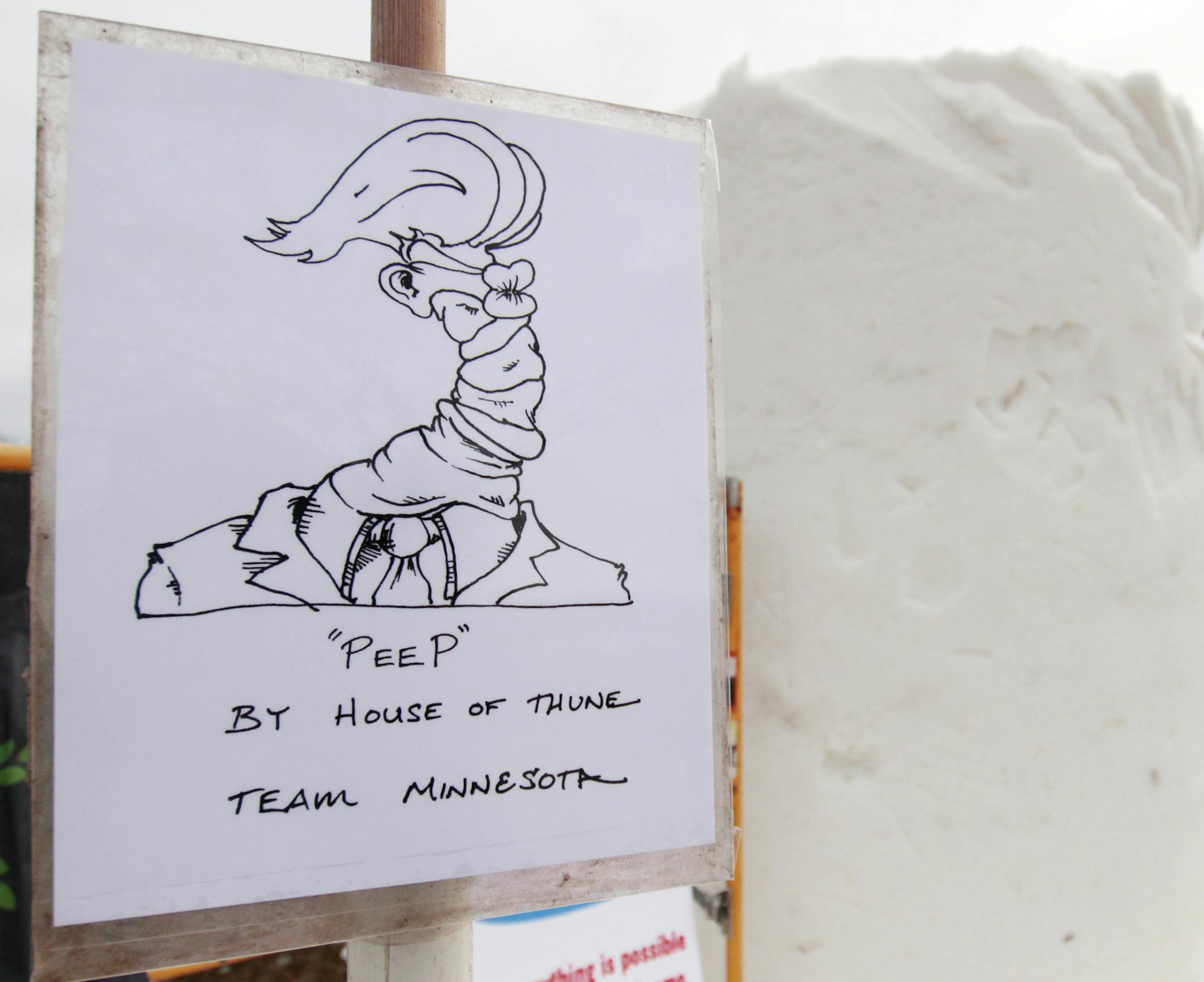 In this Jan. 31. 2018 photo, a drawing sits as an example for Team Minnesota at the U.S. National Snow Sculpting Championship in Lake Geneva, Wis. Fifteen teams from 10 states have gathered in Wisconsin for the annual event. Dusty Thune, from the Minnesota team, said they are creating a twisted President Donald Trump face in a suit called "Peep," with the caption "Tweet with a Twist." The entries will be judged Saturday on creativity, technique and message. (AP Photo/Carrie Antlfinger) ORG XMIT: