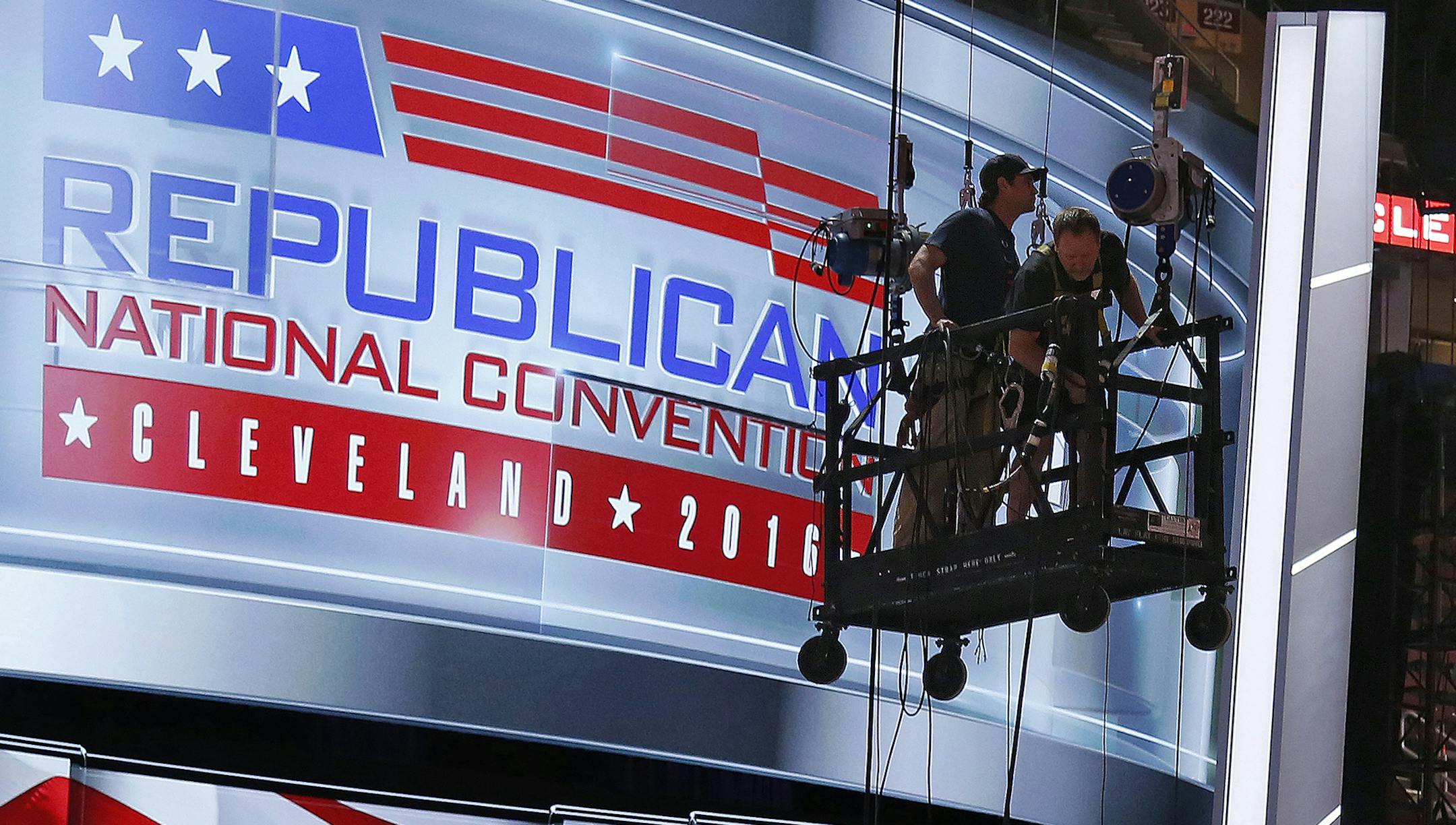 The main stage on the convention floor at the Quicken Loans Arena in downtown Cleveland, Ohio, is prepared for the upcoming Republican National Convention, as workers stand in a man lift on Wednesday, July 13, 2016. (AP Photo/Gene J. Puskar) ORG XMIT: MIN2016071323425802