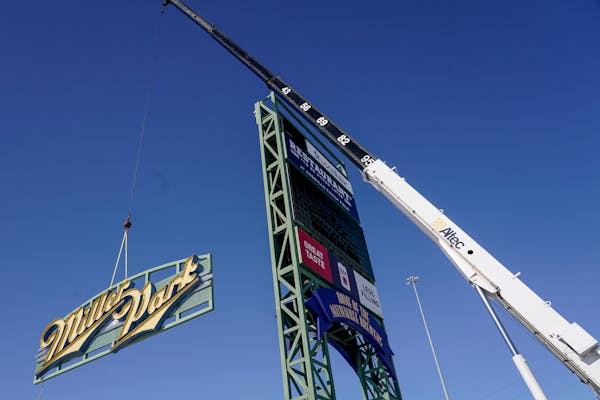 Workers remove a Miller Park sign before replacing it with an American Family Field sign Wednesday, Jan. 27, 2021, in Milwaukee. The sign replaces the
