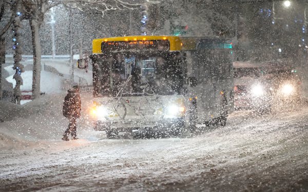 A commuter boards a metro bus in heavy snow in Minneapolis on Jan. 4. Forecasts point to the Twin Cities seeing as much as 22 inches of snow Feb. 21-2
