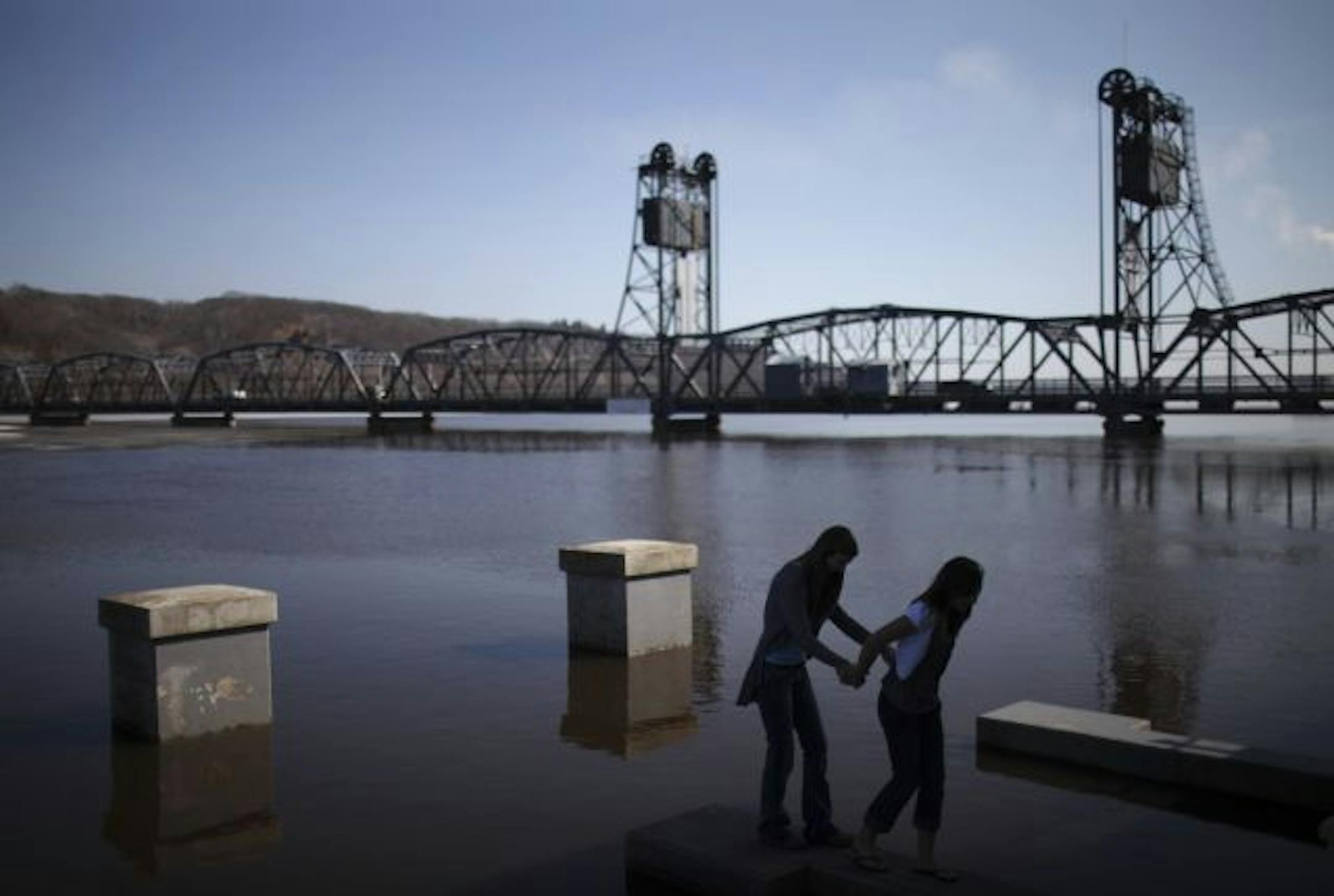 Ellie Meyer, left, and Katie Dougherty made their way back to the gazebo in Lowell Park after posing for a photo with their friend, Kaitlyn Anderson Wednesday afternoon.