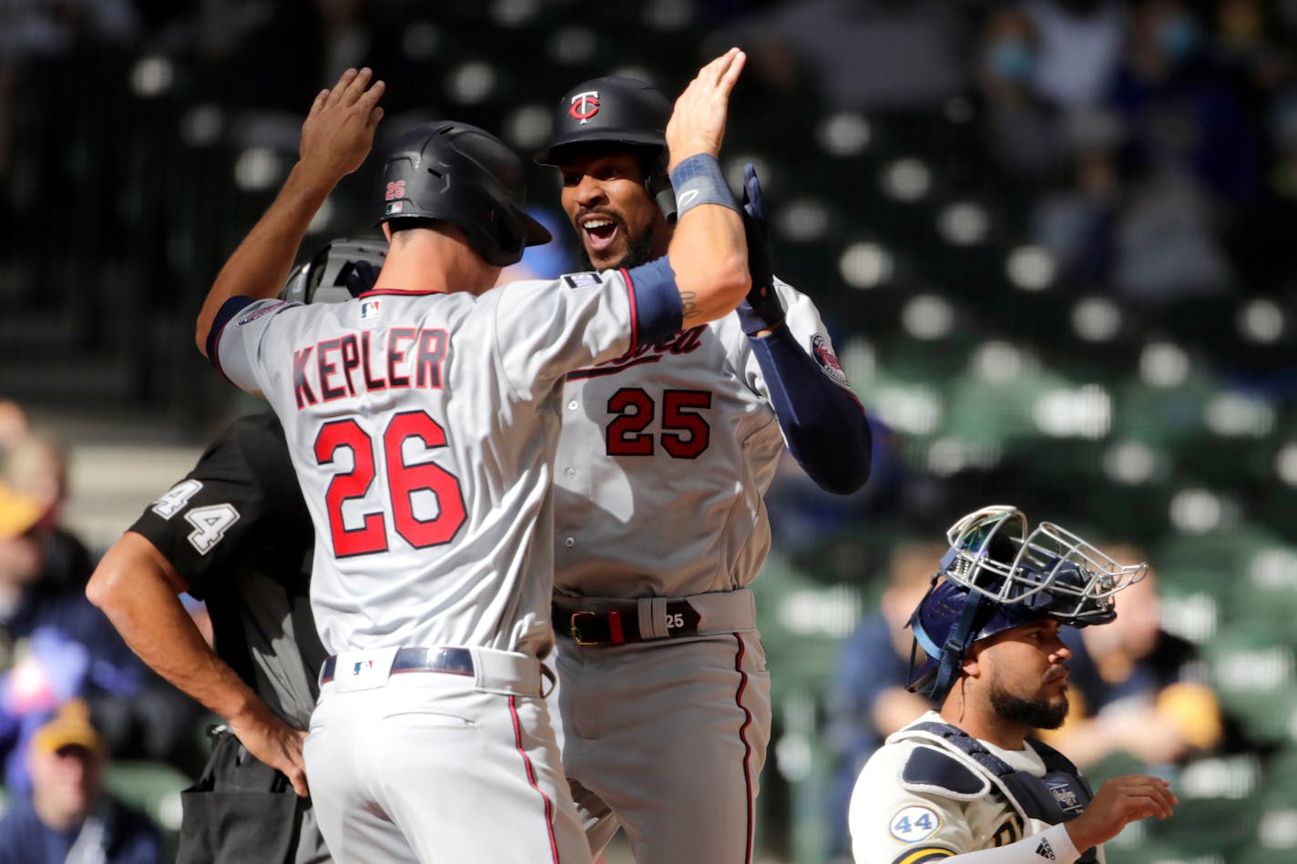 Minnesota Twins' Byron Buxton (25) is congratulated by Max Kepler (26) after hitting a two-run home run during the seventh inning of an opening day baseball game against the Milwaukee Brewers, Thursday, April 1, 2021, in Milwaukee. (AP Photo/Aaron Gash)