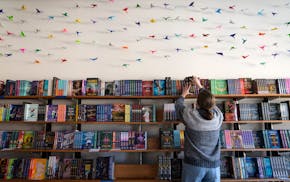 Caitlin O'Neil, co-owner of Minneapolis romance bookstore Tropes & Trifles, restacks books. The shop is part of the Twin Cities Independent Bookstore