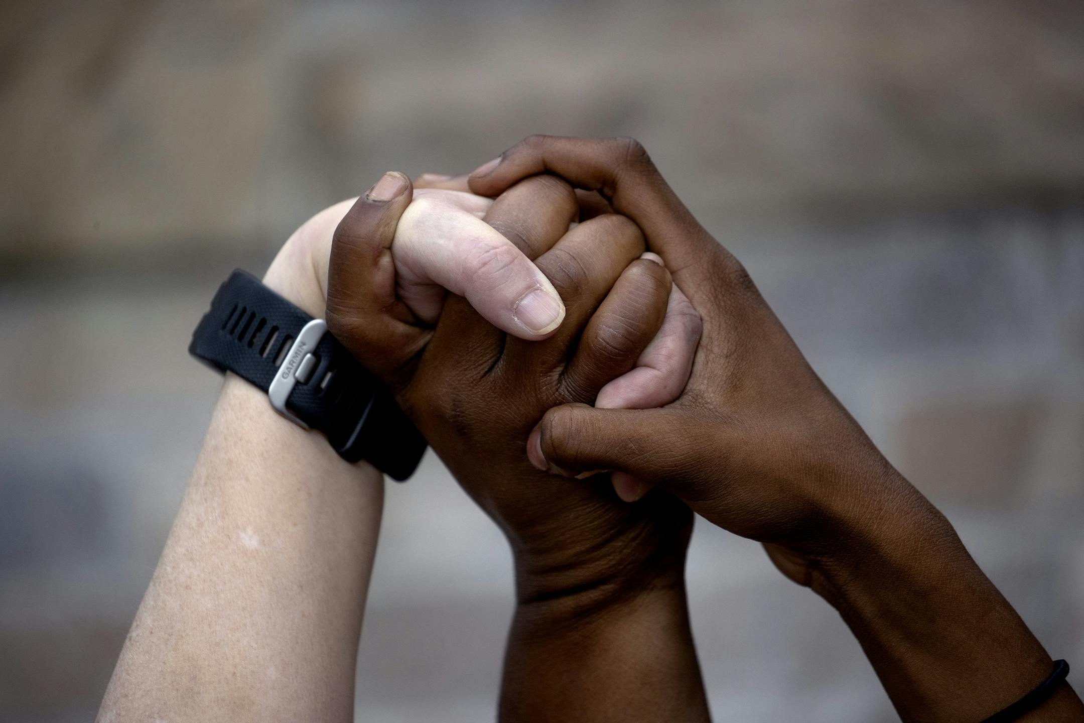Three women prayed join hands and pray around a makeshift memorial, Tuesday, May 26, 2020, in Minneapolis, near where a black man, who was taken into police custody the day before, later died. The FBI and Minnesota agents are investigating the death of a black man in Minneapolis police custody after video from a bystander showed a white officer kneeling on his neck during his arrest as he pleaded that he couldn't breathe. (Elizabeth Flores/Star Tribune via AP) ORG XMIT: MERfe8df28ff43a991b1f2cc8