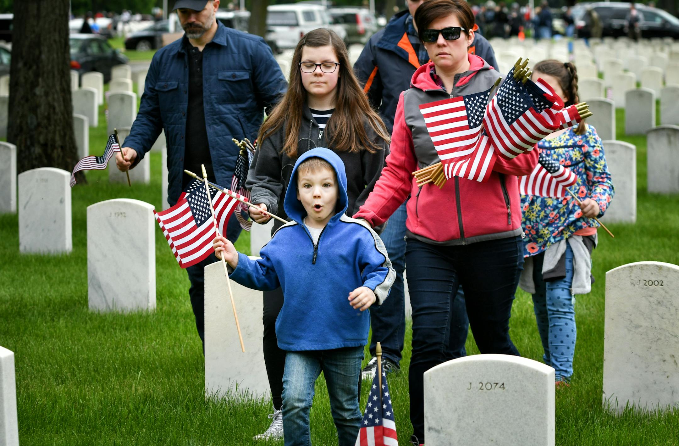 Max Payne, 5, found a grave marker where he wanted to place his flag. He came to Fort Snelling Monday with his parents Dave and Sonya and siblings Chloe, 12, Jackson, 15, Reagan, 10.