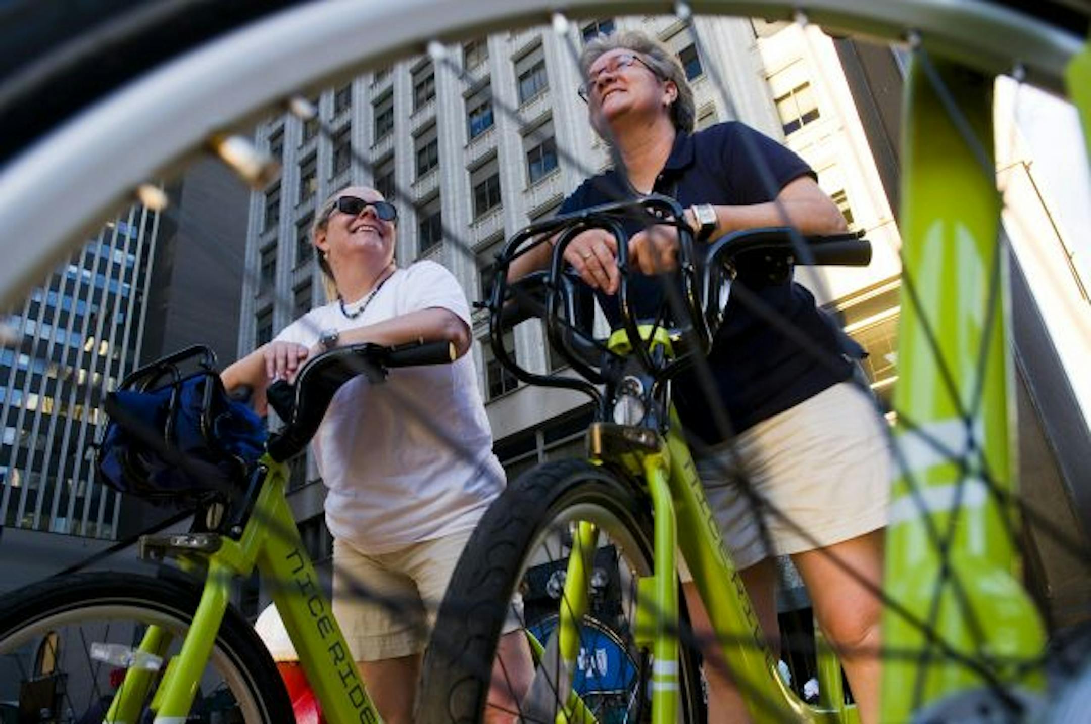 While stopped at a red light on Nicollet Mall, Erin Degutis, left, and Melanie Vanlandingham reflect on their first Nice Ride experience. Vanlandingham was visiting from Texas. "I think I'm going to be passing the word in Dallas," she said.