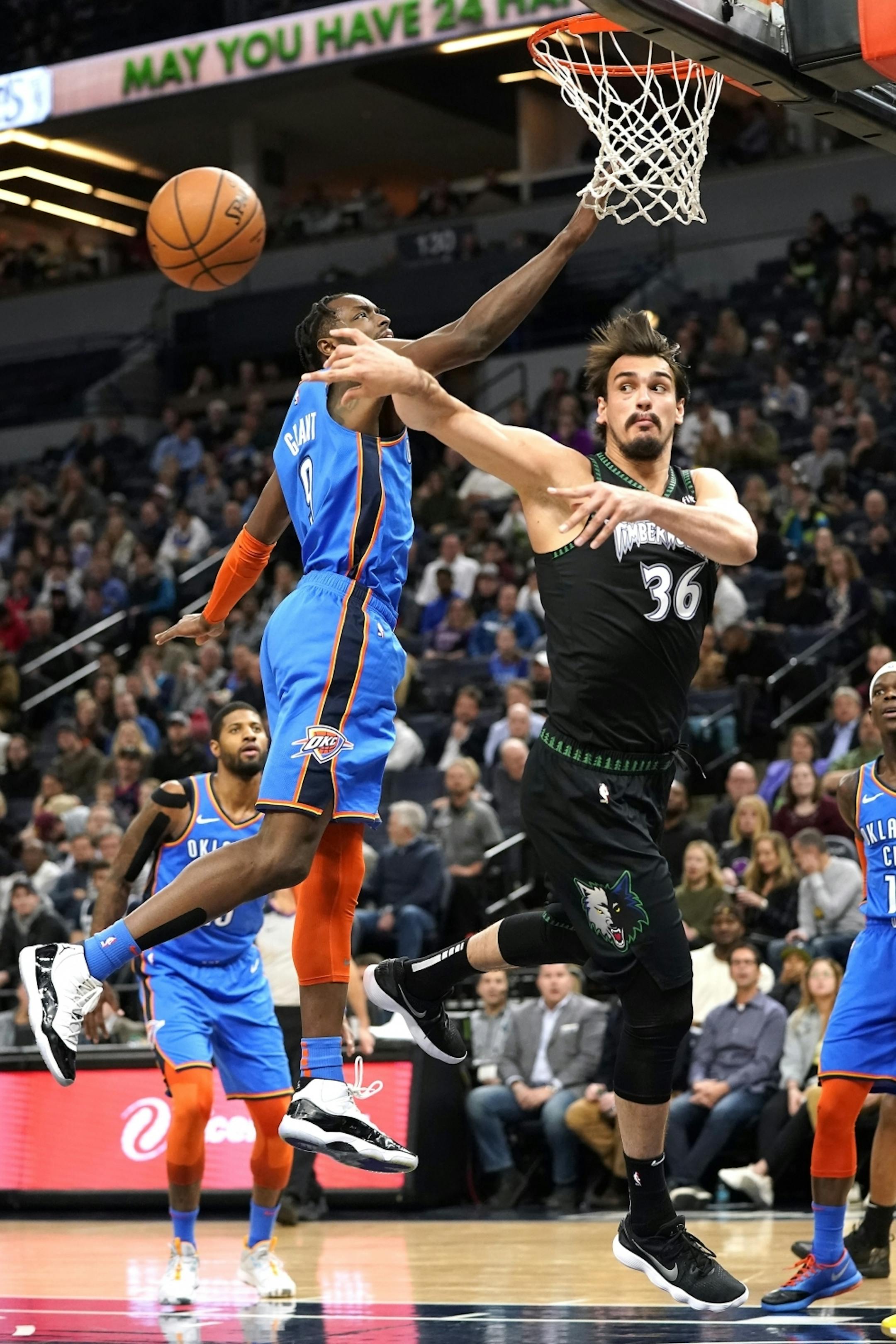 Minnesota Timberwolves forward Dario Saric (36) passes the ball under the basket as Oklahoma City Thunder forward Jerami Grant (9) defends during the first half.